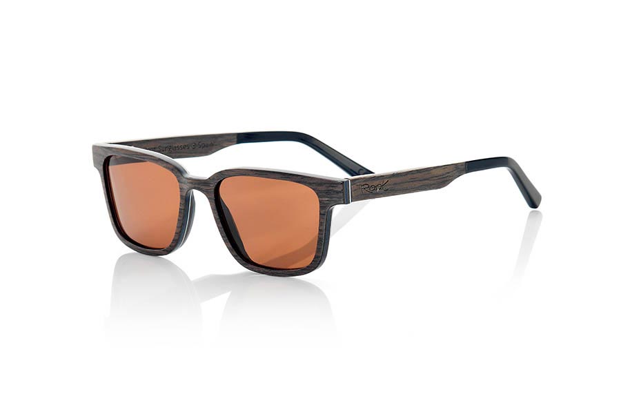 Gafas de Madera Natural de Nogal Negro SANDY. Las gafas de sol SANDY son un modelo único y elegante. Fabricadas con finísimas láminas de madera de nogal negro, estas gafas incorporan una lámina muy fina de aluminio entre las láminas de madera del frontal. El resultado es una gafa ultra fina de solo 3.8mm de espesor y ultra ligera, con solo 16 gramos de peso. Además, el refuerzo de aluminio le aporta un plus de resistencia y un toque metálico en los laterales muy elegante. Las varillas están terminadas en acetato de calidad, lo que permite su ajuste en caso de ser necesario. Te sorprenderá la belleza de la madera y sus sexys líneas angulosas, también <b>disponen de un sistema para montar lentes graduadas</b>. Medida frontal de 139x43mm



 Venta al Por Mayor y Detalle | Root Sunglasses® 