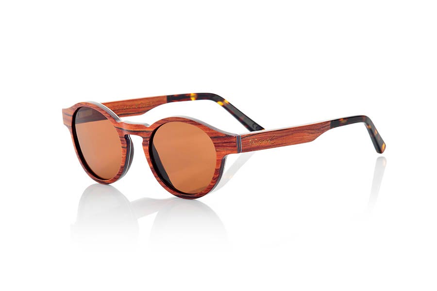 Gafas de Madera Natural de Palisandro BASIN. Las gafas de sol BASIN están fabricadas con finísimas láminas de madera de Palisandro. Incorporan una lámina muy fina de aluminio entre las láminas de madera del frontal además de una lámina coloreada azul. La gafa BASIN es un modelo redondeado con picos marcados a los lados, de un tamaño optimizado para todo tipo de caras tanto de hombres como de mujeres. Las varillas están terminadas en acetato de calidad en color carey lo que permite su ajuste en caso de ser necesario. Las BASIN Son ultra finas con sólo 3.2mm de espesor ultra ligeras sólo 17gr y el refuerzo de aluminio le aporta un plus de resistencia además de un toque metálico en los laterales muy elegante. Te sorprenderá la belleza de la madera su delgadez y su ligereza y comodidad. Las gafas de sol BASIN incluyen  un práctico estuche plegable que mantiene tus gafas seguras cuando están en su interior y ocupa muy poco espacio cuando está plegado. Medida frontal: 141x47mm Venta al Por Mayor y Detalle | Root Sunglasses® 