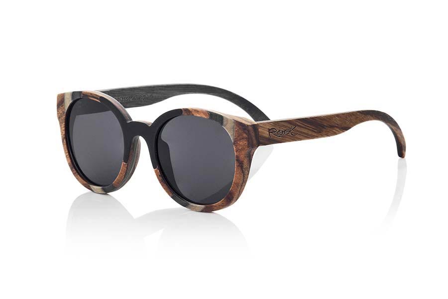 Wood eyewear of Mpingo BORNEO. BORNEO sunglasses are manufactured with a combination of 3 Woods, Mpingo (African black wood) tinted Maple and Zebrano wood. The front of this rounded glass suitable for all kinds of people of both sexes displayed a combination of these three Woods in a vertical design. He outside of the PIN is of wood of Zebra and the inside of the same is made in wood of Mpingo. This glass will back design with a touch of natural color. Front size: 146x56mm for Wholesale & Retail | Root Sunglasses® 