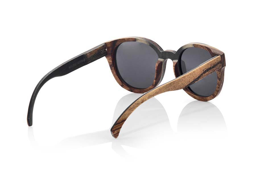 Wood eyewear of Mpingo BORNEO. BORNEO sunglasses are manufactured with a combination of 3 Woods, Mpingo (African black wood) tinted Maple and Zebrano wood. The front of this rounded glass suitable for all kinds of people of both sexes displayed a combination of these three Woods in a vertical design. He outside of the PIN is of wood of Zebra and the inside of the same is made in wood of Mpingo. This glass will back design with a touch of natural color. Front size: 146x56mm for Wholesale & Retail | Root Sunglasses® 