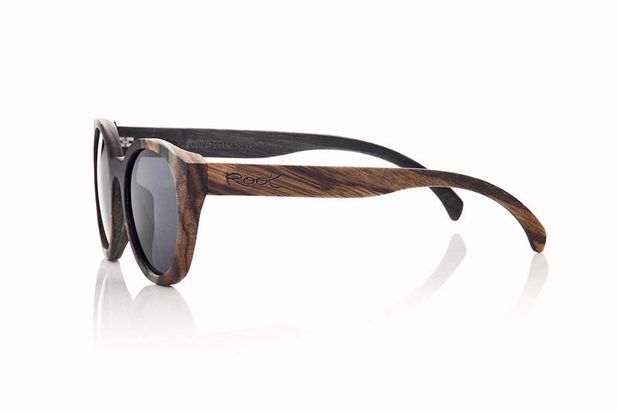 Wood eyewear of Mpingo BORNEO. BORNEO sunglasses are manufactured with a combination of 3 Woods, Mpingo (African black wood) tinted Maple and Zebrano wood. The front of this rounded glass suitable for all kinds of people of both sexes displayed a combination of these three Woods in a vertical design. He outside of the PIN is of wood of Zebra and the inside of the same is made in wood of Mpingo. This glass will back design with a touch of natural color. Front size: 146x56mm for Wholesale & Retail | Root Sunglasses® 