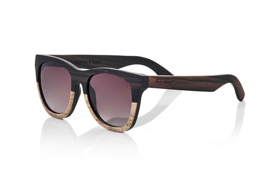 Gafas de Madera Natural de Ébano MOOREA. Las gafas de sol MOOREA están fabricadas con una combinación de 2 maderas, madera de Ébano y DuWood. El frontal de esta gafa de formas clásicas un poco redondeadas apta para todo tipo de personas de ambos sexos presenta una combinación de estas dos maderas en un diseño vertical donde la madera más oscura como lo es la madera de ébano se muestra en la parte superior y la madera Du, una madera clara similar a la madera de roble, se muestra en la parte inferior del frontal. Las patillas están fabricadas integramente en madera de ébano. Te sorprenderá la elegancia de este modelo de nuevo diseño con sus lentes degradadas. Medida frontal: 145x54mm Venta al Por Mayor y Detalle | Root Sunglasses® 