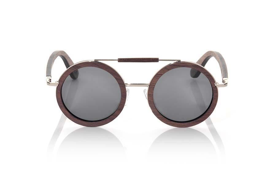 Gafas de Madera Natural de Nogal Negro JAVA. Las gafas de sol JAVA han sido fabricadas en madera de Nogal Negro, es un modelo de formas redonda de estilo boho con una adorno dorado en la ceja revesido de madera de nogal, el contorno de la madera se presenta con aro dorado y las varillas son de nogal negro. Te encantarán su forma, los detalles y la belleza de la madera de nogal. Medida Frontal: 142x57mm Venta al Por Mayor y Detalle | Root Sunglasses® 