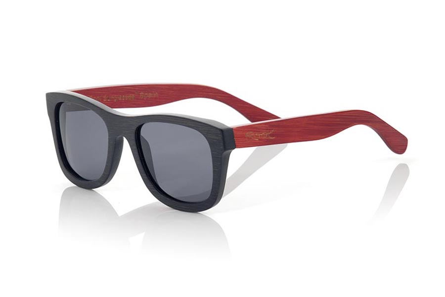 Gafas de Madera Natural de Bambú RUNA. Las gafas de sol RUNA están realizadas en madera de bambú combinando el frontal en bambú natural con un tintado negro con las varillas en bambú natural con un tintado rojo, es una montura clásica de un tamaño que se adapta bien a todo tipo de caras tanto de hombres como de mujeres. Las RUNA son una apuesta en rojo que mantiene limpia tu mirada.  Medida frontal: 146x50 Venta al Por Mayor y Detalle | Root Sunglasses® 