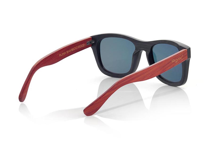 Gafas de Madera Natural de Bambú RUNA. Las gafas de sol RUNA están realizadas en madera de bambú combinando el frontal en bambú natural con un tintado negro con las varillas en bambú natural con un tintado rojo, es una montura clásica de un tamaño que se adapta bien a todo tipo de caras tanto de hombres como de mujeres. Las RUNA son una apuesta en rojo que mantiene limpia tu mirada.  Medida frontal: 146x50 Venta al Por Mayor y Detalle | Root Sunglasses® 