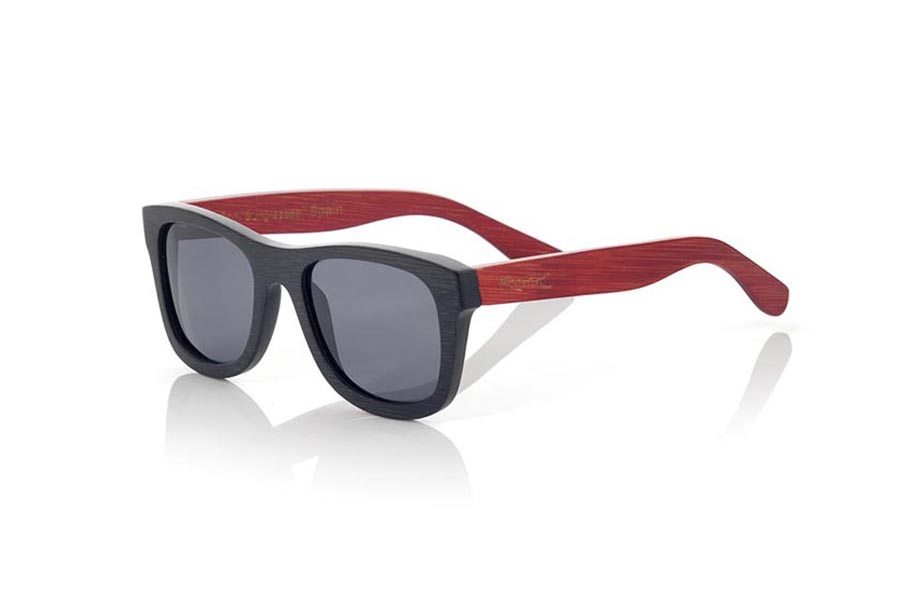 Wood eyewear of Bamboo modelo RUNA S. RUNA S sunglasses are made of bamboo wood combining the front in natural bamboo with a black tinted with natural bamboo sideburns with a RED tint, is a classic mount with a small size for people who feel better glasses  Small. The RUNA S are a bet in blue that keeps your eyes clean.  Frontal measurement: 136x44 | Root Sunglasses® 