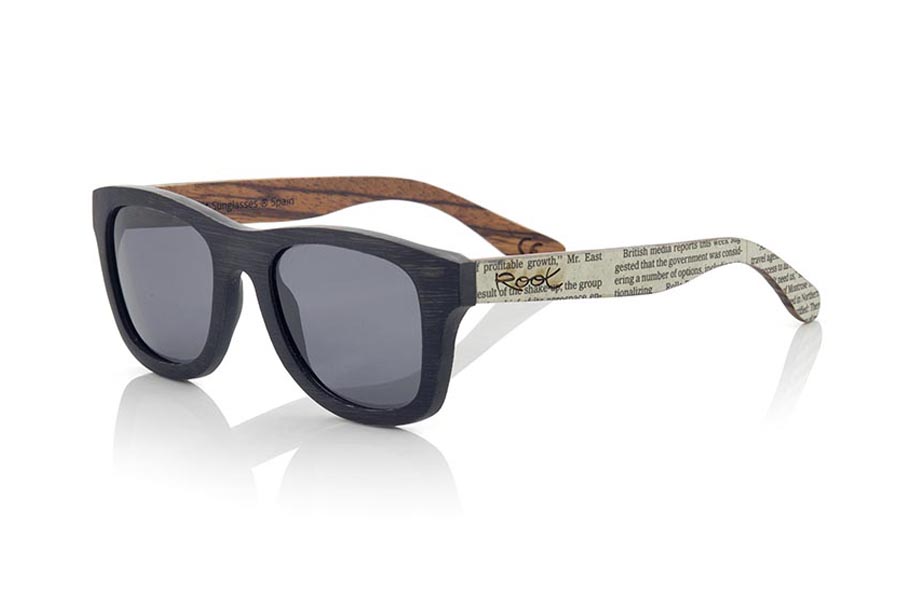 Gafas de Madera Natural de Bambú modelo SANS. Las gafas de sol SANS están realizadas en madera de bambú combinando el frontal en bambú natural con un tintado negro con las varillas en madera de zebra natural revestidas con páginas de periódicos, es una montura clásica de un tamaño que se adapta bien a todo tipo de caras tanto de hombres como de mujeres. Las SANS son una apuesta original y exclusiva. Las SANS son un módelo todavía más exclusivo ya que todas las páginas de periodicos utilizadas son diferentes entre si, por esta razón el modelo recibido puede no ser exactamente igual al modelo mostrado.  Medida frontal: 146x50 | Root Sunglasses® 