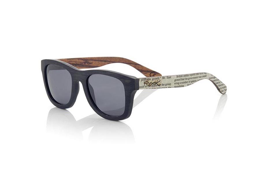 Gafas de Madera Natural de Bambú SANS S. Las gafas de sol SANS S están realizadas en madera de bambú combinando el frontal en bambú natural con un tintado negro con las varillas en madera de zebra natural revestidas con páginas de periodicos, es una montura clásica con un tamaño reducido para las personas a las que les sientan mejor las gafas más pequeñas. Las SANS S son una apuesta original y exclusiva. Las SANS S son un modelo todavía más exclusivo ya que todas las páginas de periodicos utilizadas son diferentes entre si por esta razón el modelo recibido puede no ser exactamente igual al modelo mostrado.  Medida frontal: 136x44mm Venta al Por Mayor y Detalle | Root Sunglasses® 