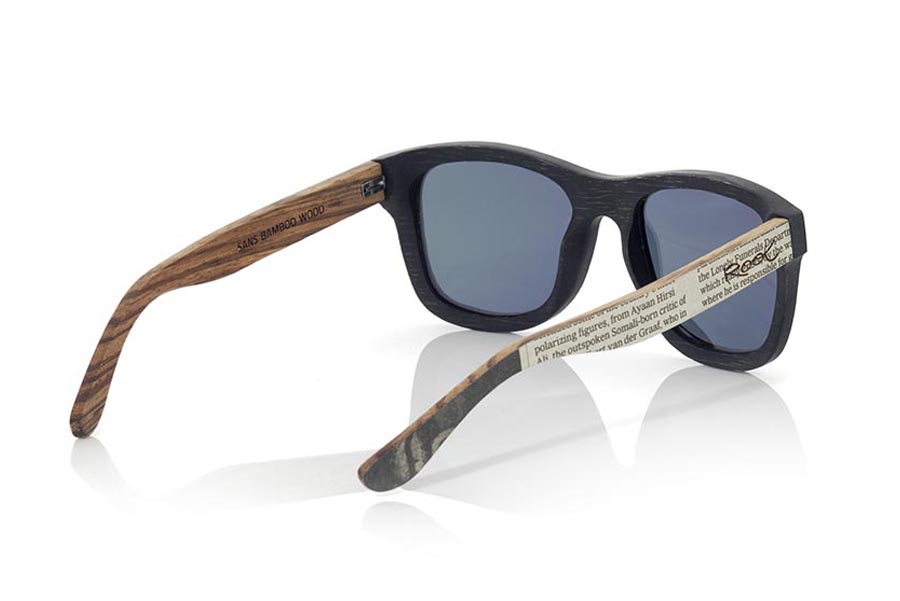 Gafas de Madera Natural de Bambú SANS. Las gafas de sol SANS están realizadas en madera de bambú combinando el frontal en bambú natural con un tintado negro con las varillas en madera de zebra natural revestidas con páginas de periódicos, es una montura clásica de un tamaño que se adapta bien a todo tipo de caras tanto de hombres como de mujeres. Las SANS son una apuesta original y exclusiva. Las SANS son un módelo todavía más exclusivo ya que todas las páginas de periodicos utilizadas son diferentes entre si, por esta razón el modelo recibido puede no ser exactamente igual al modelo mostrado.  Medida frontal: 146x50 Venta al Por Mayor y Detalle | Root Sunglasses® 