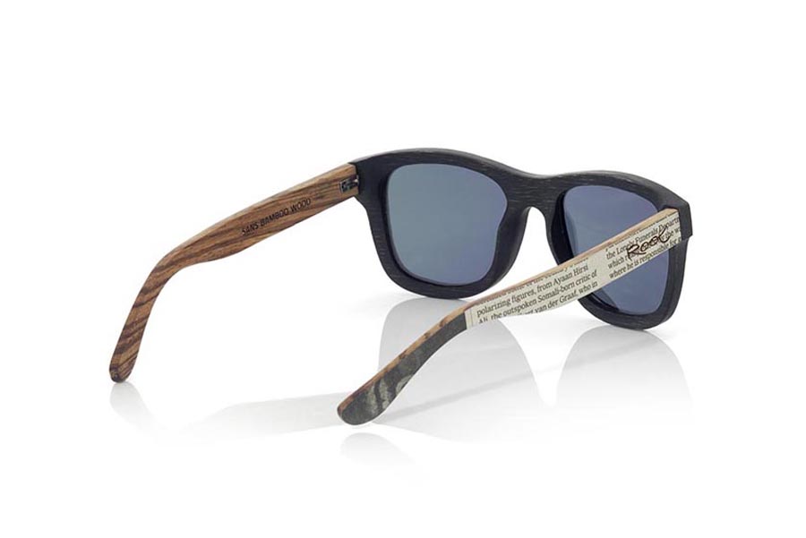 Gafas de Madera Natural de Bambú SANS S. Las gafas de sol SANS S están realizadas en madera de bambú combinando el frontal en bambú natural con un tintado negro con las varillas en madera de zebra natural revestidas con páginas de periodicos, es una montura clásica con un tamaño reducido para las personas a las que les sientan mejor las gafas más pequeñas. Las SANS S son una apuesta original y exclusiva. Las SANS S son un modelo todavía más exclusivo ya que todas las páginas de periodicos utilizadas son diferentes entre si por esta razón el modelo recibido puede no ser exactamente igual al modelo mostrado.  Medida frontal: 136x44mm Venta al Por Mayor y Detalle | Root Sunglasses® 