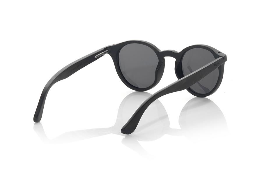 Wood eyewear of Ebony SOMAD. SOMAD sunglasses are a perfect combination of classic design and natural materials. Its rounded frame is made of laminated ebony wood, which gives it a unique and elegant appearance. The temples, thin and also made of ebony wood, complement the rounded design of the frame. The beauty and quality of this particular wood can be seen in every detail of the glasses. These sunglasses are an excellent option for those looking for a timeless design and unmatched quality. In addition, <b>they have a system for mounting prescription lenses</b>, which makes them an ideal option for those who need visual correction. With a front measurement of 137x50mm, for Wholesale & Retail | Root Sunglasses® 