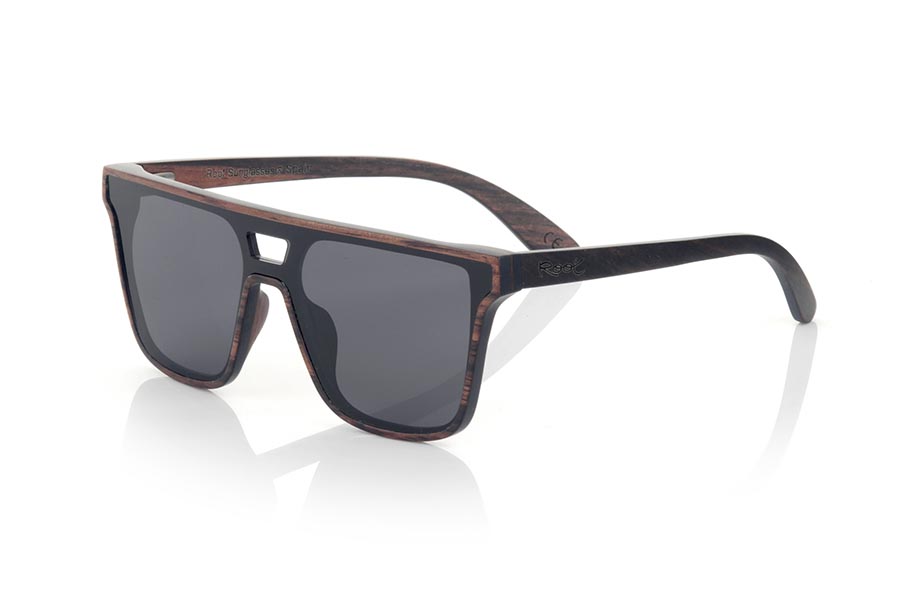 Gafas de Madera Natural de ebony RIAD. Las gafas de sol RIAD están fabricadas en madera de ébano natural. Se trata de un modelo cuadrado con lente total y un marco de madera muy sutil con el puente agujereado de caracter masculino pero seguro que a alguna de ellas también le gusta. De  tamaño amplio las RIAD sorprenden por la belleza de la madera en combinaciópn con la lente Total . Medida frontal: 145x50mm Venta al Por Mayor y Detalle | Root Sunglasses® 