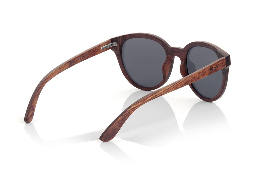 Wood eyewear of rosewood SENA. SENA sunglasses are made of natural rosewood. It is a rounded model with total lens and a very subtle wooden frame. SENA surprises with the beauty of wood in combination with the Total lens. Front measurement: 145x54mm for Wholesale & Retail | Root Sunglasses® 