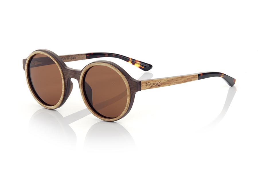 Wood eyewear of Walnut NILIA. The NILIA sunglasses are manufactured in a combination of two woods, black walnut in frame and oak in the outer ring of the frame and temples. The latter are finished in hawksbill acetate with an internal rod, which allows it to be adjusted if necessary. It is a rounded model with its own personality with a very careful finish. Front measurement: 140x50mm for Wholesale & Retail | Root Sunglasses® 