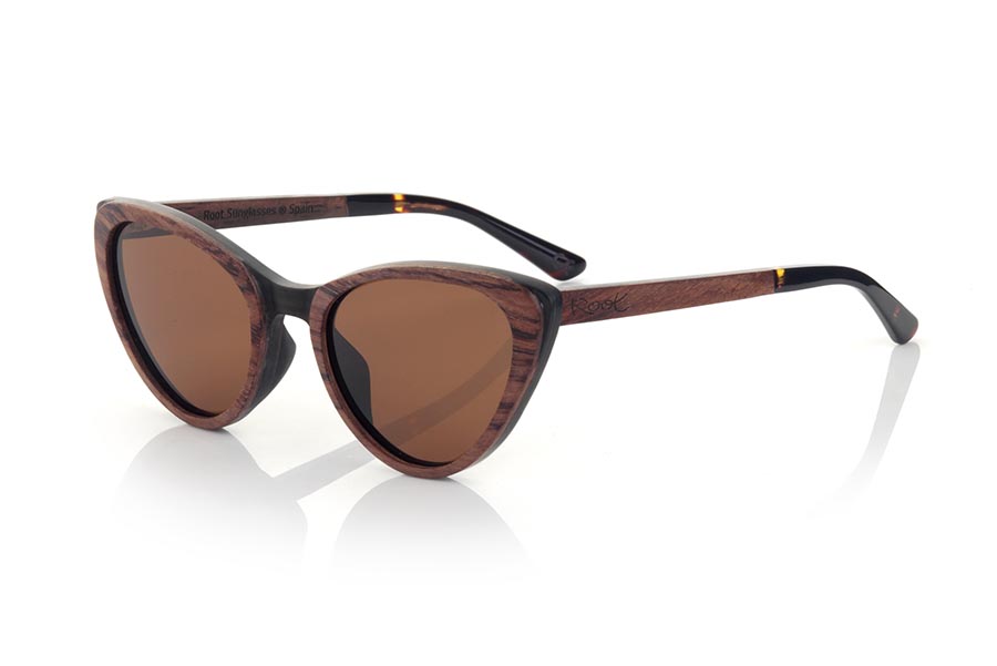 Wood eyewear of rosewood modelo LOUISE. LOUISE sunglasses are manufactured in a combination of two woods, MPINGO (African Black wood) in frame and Rosewood in the outer ring of the frame and sideburns. The latter are finished in hawksbill acetate with internal rod which allow to be adjusted if necessary. It is a cat-style model with its own personality and a very careful finish. Front measurement: 145x50mm | Root Sunglasses® 