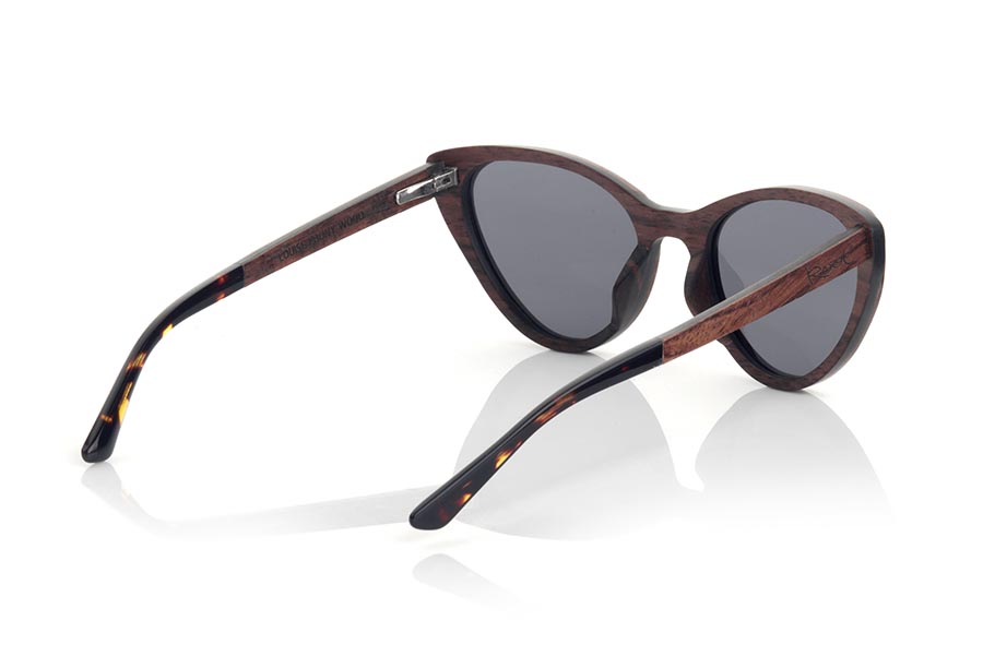 Wood eyewear of rosewood LOUISE. LOUISE sunglasses are manufactured in a combination of two woods, MPINGO (African Black wood) in frame and Rosewood in the outer ring of the frame and sideburns. The latter are finished in hawksbill acetate with internal rod which allow to be adjusted if necessary. It is a cat-style model with its own personality and a very careful finish. Front measurement: 145x50mm for Wholesale & Retail | Root Sunglasses® 