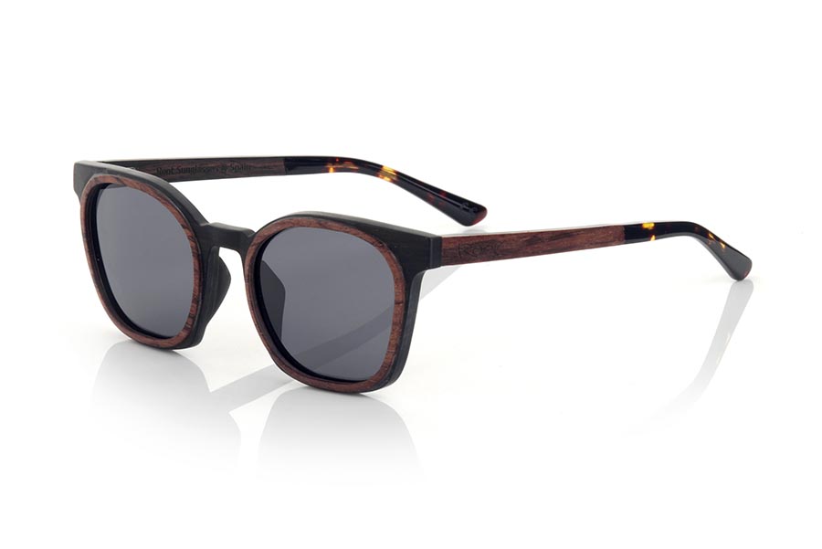 Wood eyewear of ebony modelo GUSTAV. GUSTAV sunglasses are manufactured in a combination of two woods, ebony in the frame and inside of the temples and Rosewood in the outer ring of the frame and the outside of the temples. The latter are finished in carey acetate with internal rod which allow to be adjusted if necessary. It is a model with its own personality and a very careful finish that will surprise you with its originality and the combination of woods. Front measurement: 141x48mm | Root Sunglasses® 