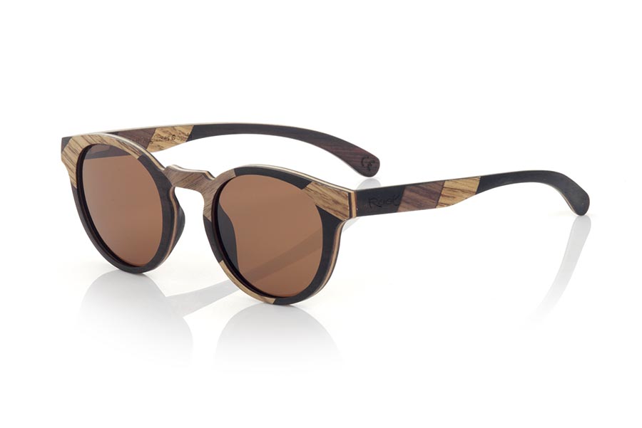 Wood eyewear of Walnut NEILY. NEILY sunglasses are manufactured in a combination of three spectacular woods, Black Walnut, Oak and African Black wood (Mpingo) in frame and temples. The latter are finished in hawksbill acetate with internal rod which allow to be adjusted if necessary. It is a finely executed elegant and original model with a very careful finish that will surprise you with its originality and the combination of woods. Front measurement: 140x48mm for Wholesale & Retail | Root Sunglasses® 