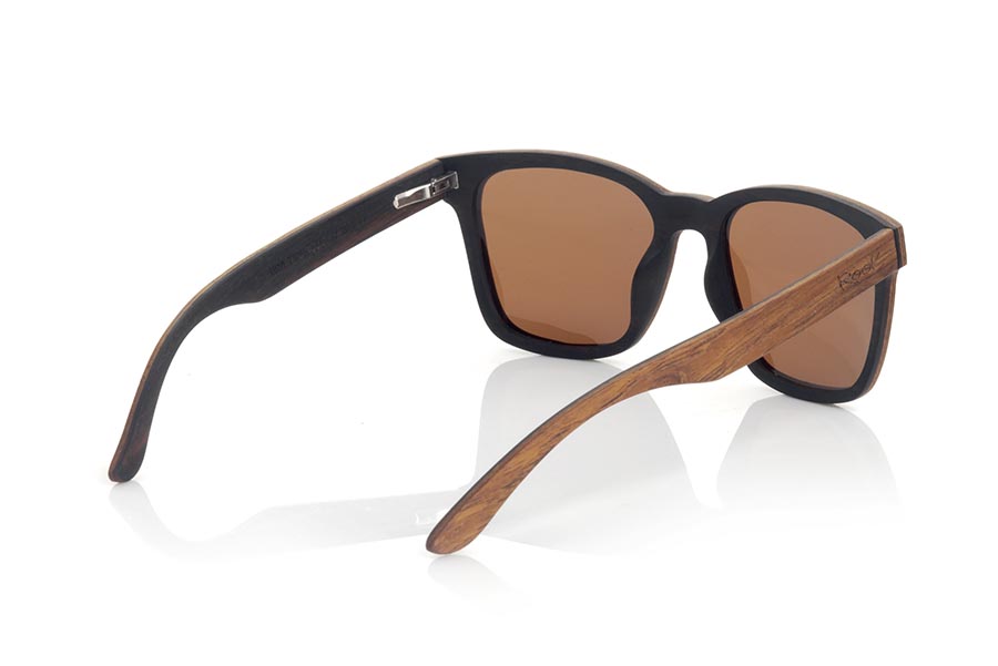 Wood eyewear of ebony URA. The URA sunglasses are manufactured in a combination of two woods, Ebony in the lower part of the frame and inside the temples and Rosewood in the upper part of the frame and outside the temples. It is a simple and elegant, easy to wear model with a very careful finishing that will surprise you with its originality and the combination of woods. Front measure: 145x50mm for Wholesale & Retail | Root Sunglasses® 