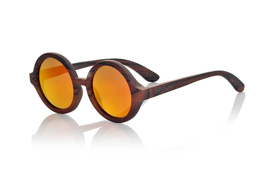 Gafas de Madera Natural de Ébano TANA. Las gafas de sol Tana están realizadas en madera de Ébano. Modelo circular estricto realizado en una bellísima madera combinada con lentes Grises, Gris REVO, Morado REVO o Naranja REVO. Te sorprenderá su originalidad y las diferentes combinaciones de lentes. Medida Frontal: 138x55mm Venta al Por Mayor y Detalle | Root Sunglasses® 