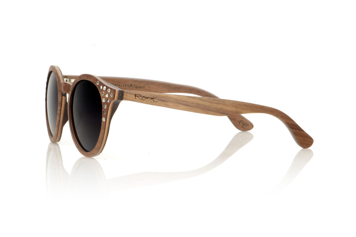 Wood eyewear of Walnut LANA. LANA wooden sunglasses, from our collection of organic glasses, entirely made of laminated walnut wood. This model perfectly combines natural elegance with an iconic design: a rounded shape with a straight eyebrow, creating a visual balance that enhances any type of face. But what really sets LANA apart are the sparkling Czech crystals embedded at the ends of the brows, adding a touch of light and sophistication. Ideal for those looking to stand out with a unique accessory, LANA is not just a pair of glasses, but a statement of style and ecological awareness. Measurements 147x50mm Caliber 47 for Wholesale & Retail | Root Sunglasses® 