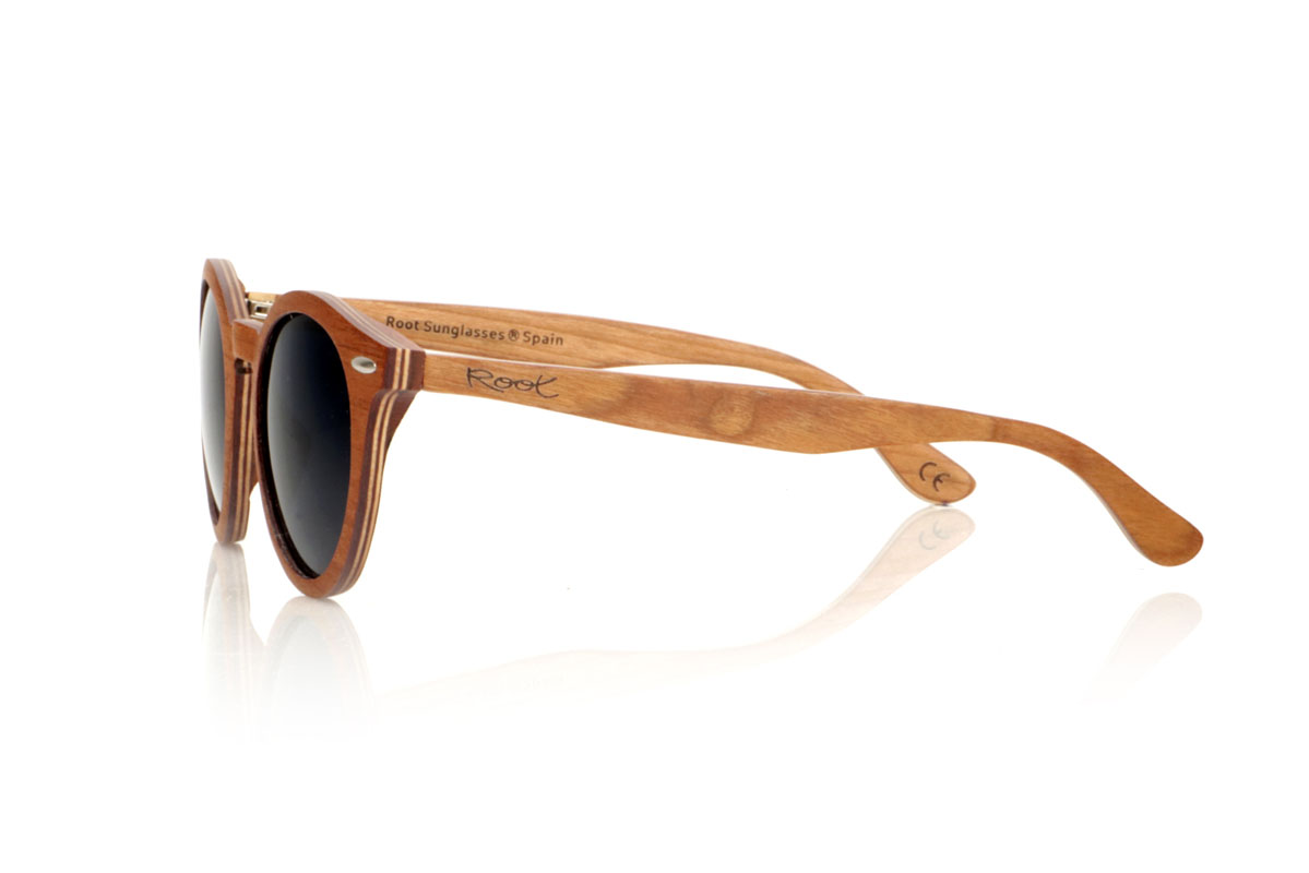 Wood eyewear of Cherry LINDA. The LINDA wooden sunglasses come with a rounded and elegant silhouette, standing out for their cross-laminated cherry wood frame, which not only guarantees durability but also a unique style thanks to its beautiful grain. Silver metal pins on the front add a touch of class, balancing the warmth of the wood with a subtle shine. With tighter measurements of 140x49 and a caliber of 48, these glasses offer a comfortable fit and versatile style, perfect for those looking for a sophisticated and timeless accessory. for Wholesale & Retail | Root Sunglasses® 