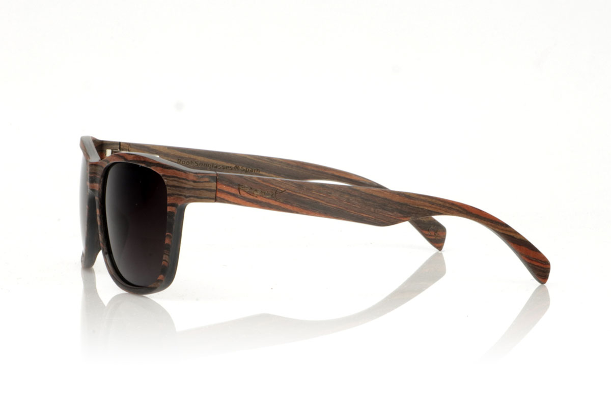 Wood eyewear of Ebony ELEGANCE. ELEGANCE wooden sunglasses stand out for their less angular frame, designed to fit wider faces or for those who prefer oversized glasses. This model is characterized by its unique construction, with laminated ebony wood on the exterior and interior and sheets of maple wood interspersed on the contravein, and by the detail of the curvature of the frame in the grip to the temples, offering not only an effect Impressive visual but also a robust structure. With generous measurements of 155x50mm and a caliber of 55, these glasses are the perfect choice for those looking to combine comfort with a bold and elegant style. for Wholesale & Retail | Root Sunglasses® 