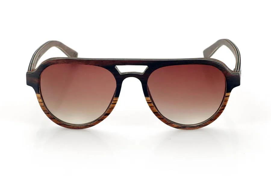 Wood eyewear of Ebony FLYER SK. FLYER SK sunglasses are handcrafted entirely from laminated wood, combining ebony, walnut and zebrawood. Their aviator-inspired design maintains a classic aesthetic with a distinctive bridge, providing a balance between style and functionality.
The laminated wood structure enhances the natural grain of each material, providing an organic and lightweight finish. Thanks to its layered construction, this model offers strength and comfort for daily use.
High-quality polarized lenses guarantee total UV protection and reduce glare, improving visual clarity. A timeless design that connects with nature without sacrificing protection and comfort.
Dimensions 144x52mm. Caliber 53. for Wholesale & Retail | Root Sunglasses® 