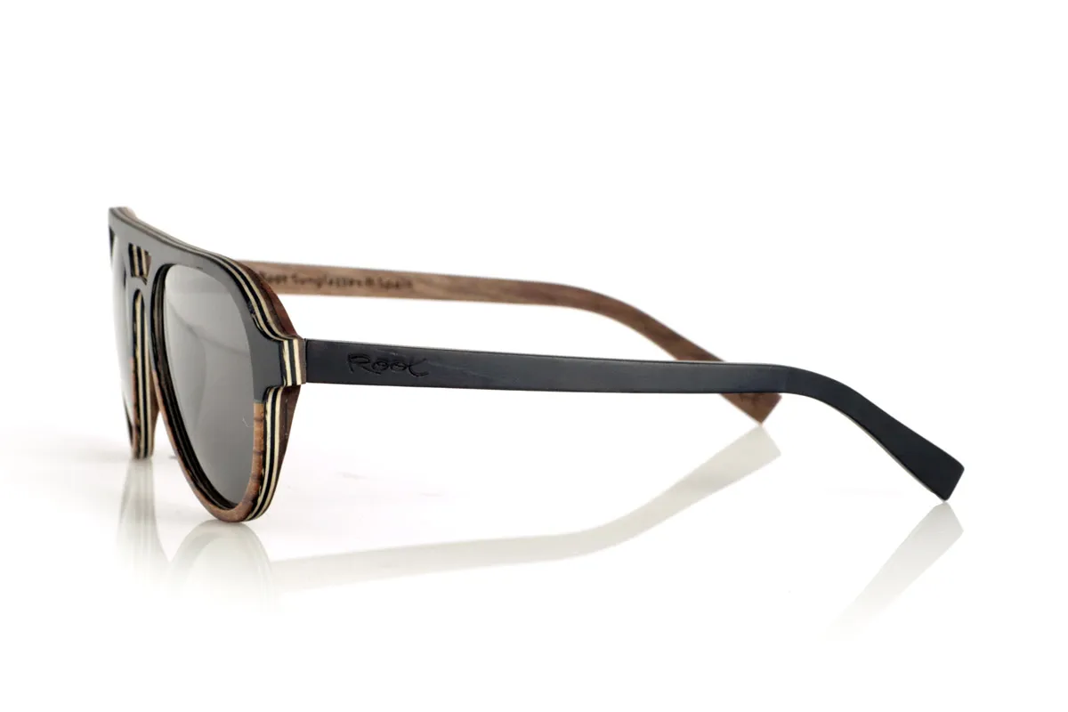 Wood eyewear of Ebony FLYER SK. FLYER SK sunglasses are handcrafted entirely from laminated wood, combining ebony, walnut and zebrawood. Their aviator-inspired design maintains a classic aesthetic with a distinctive bridge, providing a balance between style and functionality.
The laminated wood structure enhances the natural grain of each material, providing an organic and lightweight finish. Thanks to its layered construction, this model offers strength and comfort for daily use.
High-quality polarized lenses guarantee total UV protection and reduce glare, improving visual clarity. A timeless design that connects with nature without sacrificing protection and comfort.
Dimensions 144x52mm. Caliber 53. for Wholesale & Retail | Root Sunglasses® 