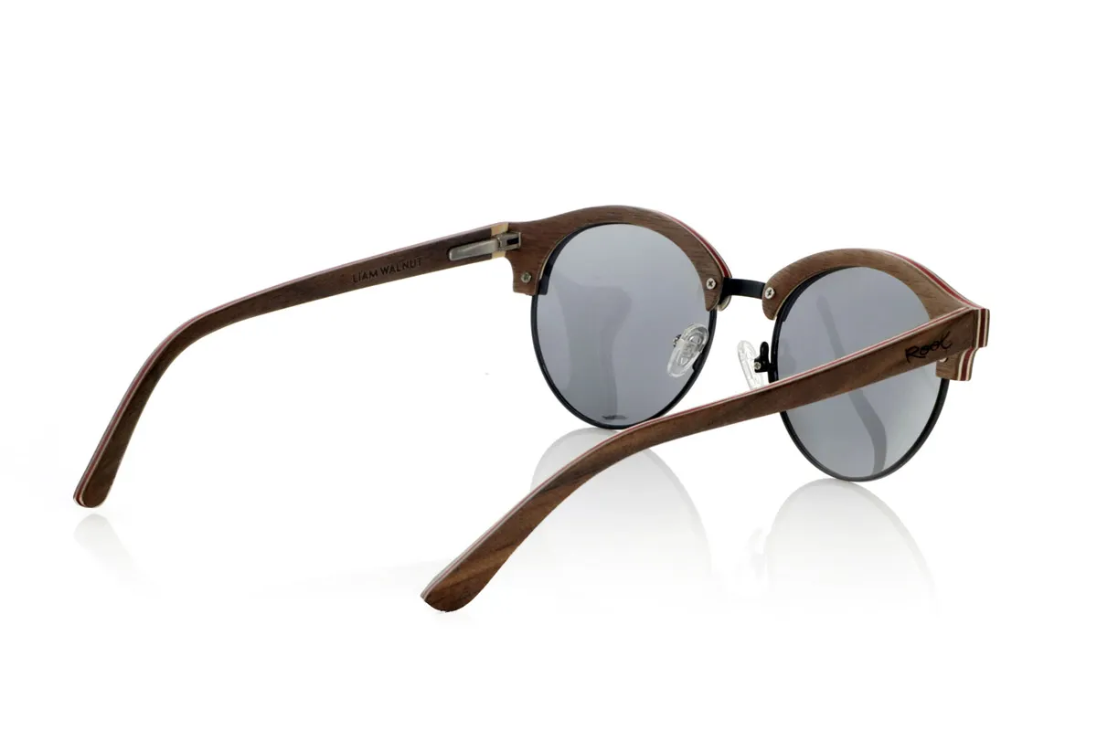 Wood eyewear of Walnut LIAM. The LIAM are handcrafted from laminated walnut wood, with natural maple interior slats and red details. Their design combines the elegance of the classics with a contemporary touch, highlighting the curved lines and the metal structure on the bridge for greater resistance.
The laminated wood provides durability without compromising lightness, allowing a comfortable fit for everyday use. The combination of natural materials and detailed finishes enhances the unique character of each piece.
High-quality polarized lenses offer total UV protection, minimizing reflections and guaranteeing clear vision. A versatile design that unites tradition and modernity in wooden sunglasses designed for those who value authenticity and comfort.
Dimensions 140x50mm. Caliber 50. for Wholesale & Retail | Root Sunglasses® 