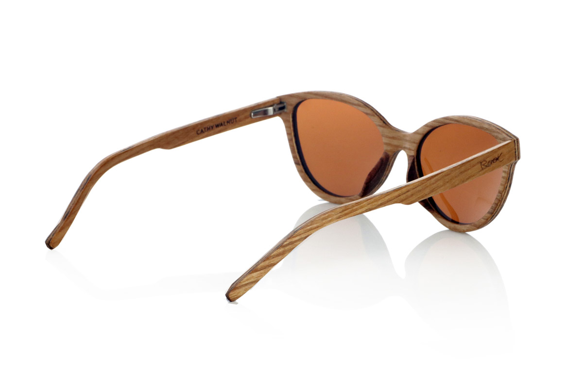 Gafas de Madera Natural de Walnut CATHY. Las CATHY son gafas de sol fabricadas artesanalmente en madera laminada de nogal claro y oscuro combinados, creando un contraste natural y elegante. Su diseño más pequeño que otros y de líneas suaves y montura redondeada que recuerda al ojo de gato aporta un equilibrio entre sofisticación y versatilidad, adaptándose a diferentes estilos y rostros.
La estructura de madera laminada no solo resalta las vetas naturales del material, sino que también proporciona una gran resistencia y comodidad. Gracias a su ligereza y ajuste ergonómico, este modelo es ideal para el uso diario sin comprometer la estética.
Incorporan lentes polarizadas que ofrecen protección total contra los rayos UV y reducen los reflejos, garantizando una visión nítida en cualquier entorno. Un diseño atemporal que fusiona artesanía y funcionalidad en unas gafas de madera únicas.

Dimensiones: 135x48 mm. Calibre 52. Venta al Por Mayor y Detalle | Root Sunglasses® 