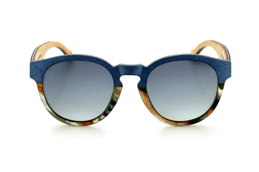 Wood eyewear of Maple WANZ. WANZ sunglasses are made from a combination of laminated woods that provide a unique and distinctive style. Its blue maple wood front merges with a multicoloured rainbow skateboard sheet, creating a dynamic and original visual effect. The temples, made from blue tinted maple with a natural maple wood interior, complement the design with a balance between modernity and warmth.

Thanks to their layered wood construction, these wooden sunglasses guarantee strength without compromising comfort. They incorporate high-quality polarised lenses that offer full UV protection and reduce glare, improving visual clarity.

A versatile model that stands out for its bold design and its inspiration from nature. Dimensions: 138x52mm. Caliber 49. for Wholesale & Retail | Root Sunglasses® 
