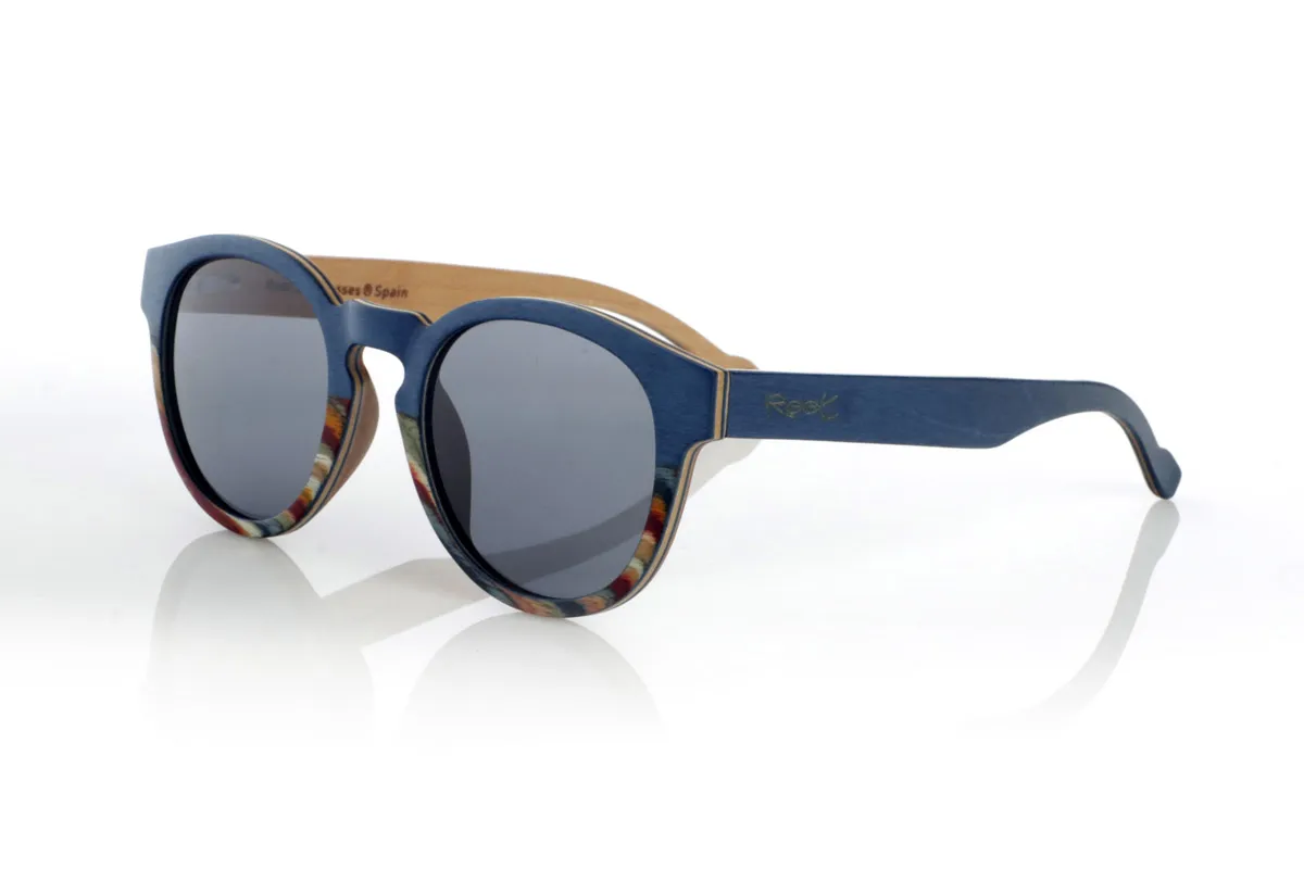 Wood eyewear of Maple WANZ. WANZ sunglasses are made from a combination of laminated woods that provide a unique and distinctive style. Its blue maple wood front merges with a multicoloured rainbow skateboard sheet, creating a dynamic and original visual effect. The temples, made from blue tinted maple with a natural maple wood interior, complement the design with a balance between modernity and warmth.

Thanks to their layered wood construction, these wooden sunglasses guarantee strength without compromising comfort. They incorporate high-quality polarised lenses that offer full UV protection and reduce glare, improving visual clarity.

A versatile model that stands out for its bold design and its inspiration from nature. Dimensions: 138x52mm. Caliber 49. for Wholesale & Retail | Root Sunglasses® 