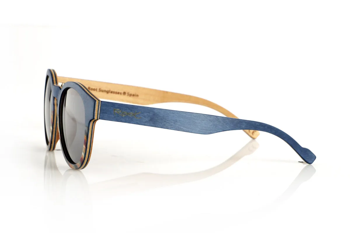 Wood eyewear of Maple WANZ. WANZ sunglasses are made from a combination of laminated woods that provide a unique and distinctive style. Its blue maple wood front merges with a multicoloured rainbow skateboard sheet, creating a dynamic and original visual effect. The temples, made from blue tinted maple with a natural maple wood interior, complement the design with a balance between modernity and warmth.

Thanks to their layered wood construction, these wooden sunglasses guarantee strength without compromising comfort. They incorporate high-quality polarised lenses that offer full UV protection and reduce glare, improving visual clarity.

A versatile model that stands out for its bold design and its inspiration from nature. Dimensions: 138x52mm. Caliber 49. for Wholesale & Retail | Root Sunglasses® 