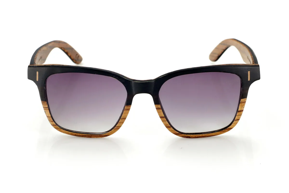 Gafas de Madera Natural de mpingo LOREA. Las gafas de sol LOREA están fabricadas en una combinación de dos maderas, Mpingo (African Black wood) en parte superior de montura y en el exterior de las varillas y Zebrano en la parte inferior de la montura y en el interior de las varillas.  Se trata de un modelo fácil de llevar sencillo y elegante con una terminación muy cuidada que te sorprenderá por su originalidad y la combinación de maderas. Medida frontal: 145x50mm Venta al Por Mayor y Detalle | Root Sunglasses® 