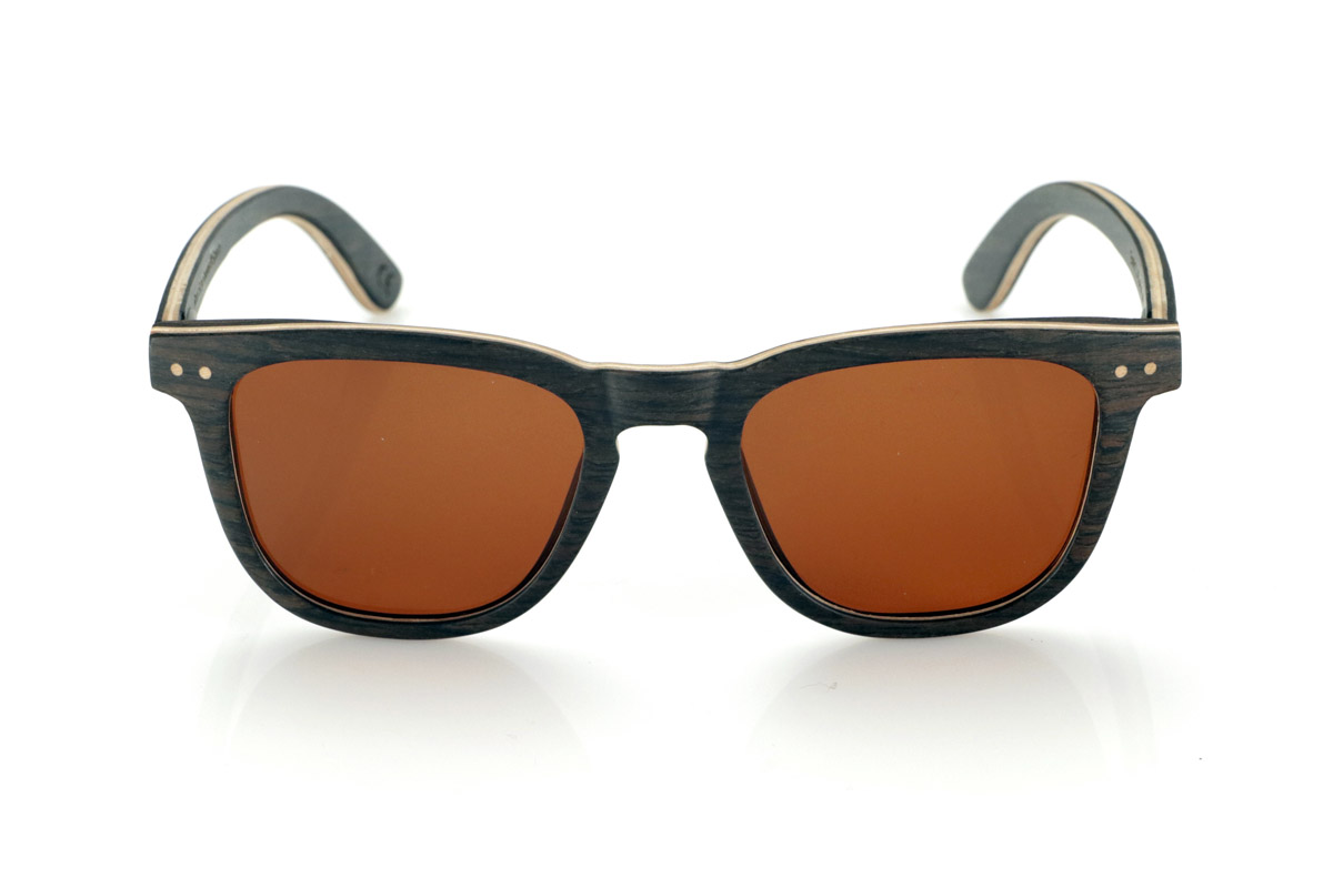 Gafas de Madera Natural de Roble ENRICO. Las gafas de sol de madera ENRICO están fabricadas con una estructura laminada de roble negro en el exterior e interior, con una fina lámina de arce natural intercalada que aporta un sutil contraste. Su diseño clásico con frontal recto y líneas definidas transmite equilibrio y solidez.

Los detalles de doble punto en el frontal resaltan su carácter artesanal, mientras que su estructura laminada proporciona resistencia sin comprometer la comodidad. Las lentes polarizadas garantizan una visión nítida, reduciendo reflejos y ofreciendo una protección total contra los rayos UV.

Un modelo atemporal que combina materiales nobles con un diseño funcional para el uso diario.

Dimensiones: 142x47mm. Calibre 49. Venta al Por Mayor y Detalle | Root Sunglasses® 