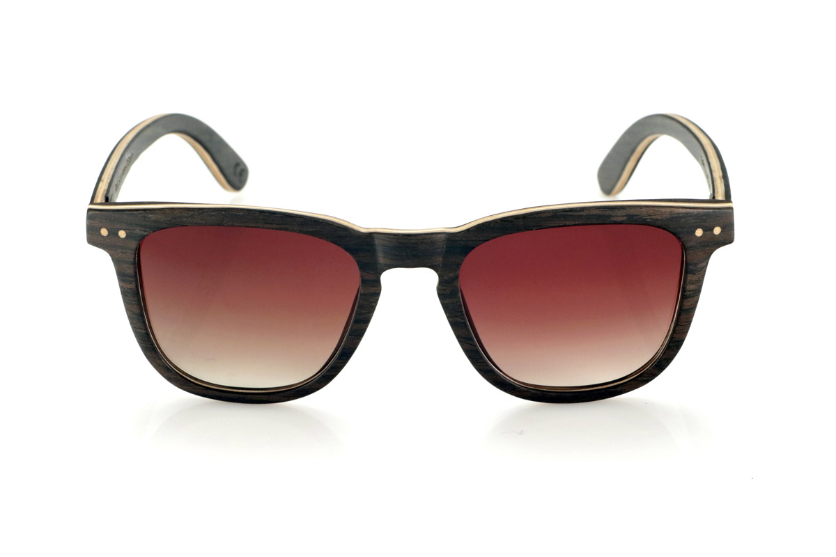 Gafas de Madera Natural de Roble ENRICO. Las gafas de sol de madera ENRICO están fabricadas con una estructura laminada de roble negro en el exterior e interior, con una fina lámina de arce natural intercalada que aporta un sutil contraste. Su diseño clásico con frontal recto y líneas definidas transmite equilibrio y solidez.

Los detalles de doble punto en el frontal resaltan su carácter artesanal, mientras que su estructura laminada proporciona resistencia sin comprometer la comodidad. Las lentes polarizadas garantizan una visión nítida, reduciendo reflejos y ofreciendo una protección total contra los rayos UV.

Un modelo atemporal que combina materiales nobles con un diseño funcional para el uso diario.

Dimensiones: 142x47mm. Calibre 49. Venta al Por Mayor y Detalle | Root Sunglasses® 