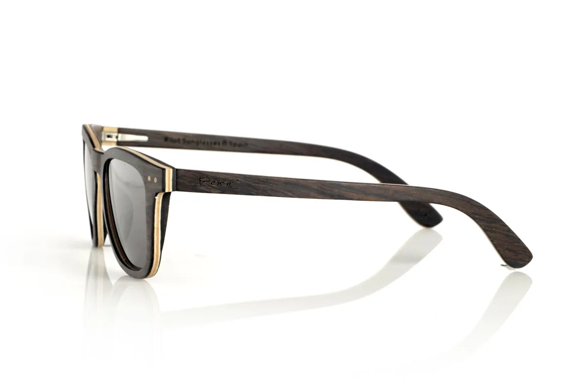 Wood eyewear of Oak ENRICO. ENRICO wooden sunglasses are made with a laminated black oak structure on the outside and inside, with a thin layer of natural maple interspersed for subtle contrast. Its classic design with a straight front and defined lines conveys balance and solidity.

Double-knit details on the front highlight its artisanal character, while its laminated structure provides strength without compromising comfort. Polarized lenses guarantee clear vision, reducing glare and offering total UV protection.

A timeless model that combines noble materials with a functional design for everyday use.

Dimensions: 142x47mm. Caliber 49. for Wholesale & Retail | Root Sunglasses® 