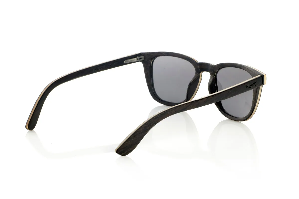 Wood eyewear of Oak ENRICO. ENRICO wooden sunglasses are made with a laminated black oak structure on the outside and inside, with a thin layer of natural maple interspersed for subtle contrast. Its classic design with a straight front and defined lines conveys balance and solidity.

Double-knit details on the front highlight its artisanal character, while its laminated structure provides strength without compromising comfort. Polarized lenses guarantee clear vision, reducing glare and offering total UV protection.

A timeless model that combines noble materials with a functional design for everyday use.

Dimensions: 142x47mm. Caliber 49. for Wholesale & Retail | Root Sunglasses® 