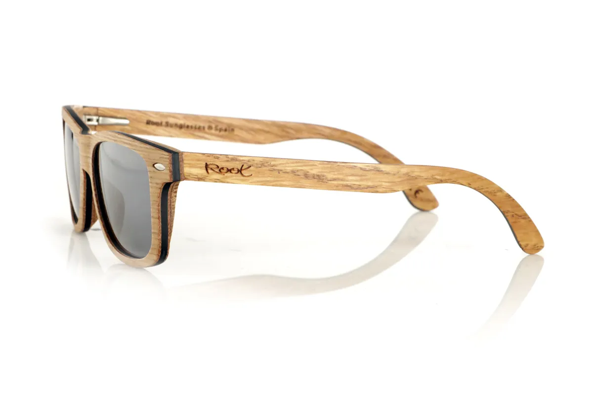 Wood eyewear of Oak RAJASTAN SK. RAJASTAN wooden sunglasses are made from a combination of laminated oak wood and a black maple inner layer, offering a sophisticated and natural style. Its rectangular design is complemented by metallic ornaments on the front, adding a touch of elegance. These wooden sunglasses are an ideal choice for those looking for an exclusive and sustainable look. Dimensions: 148x47 mm
Caliber: 49 for Wholesale & Retail | Root Sunglasses® 