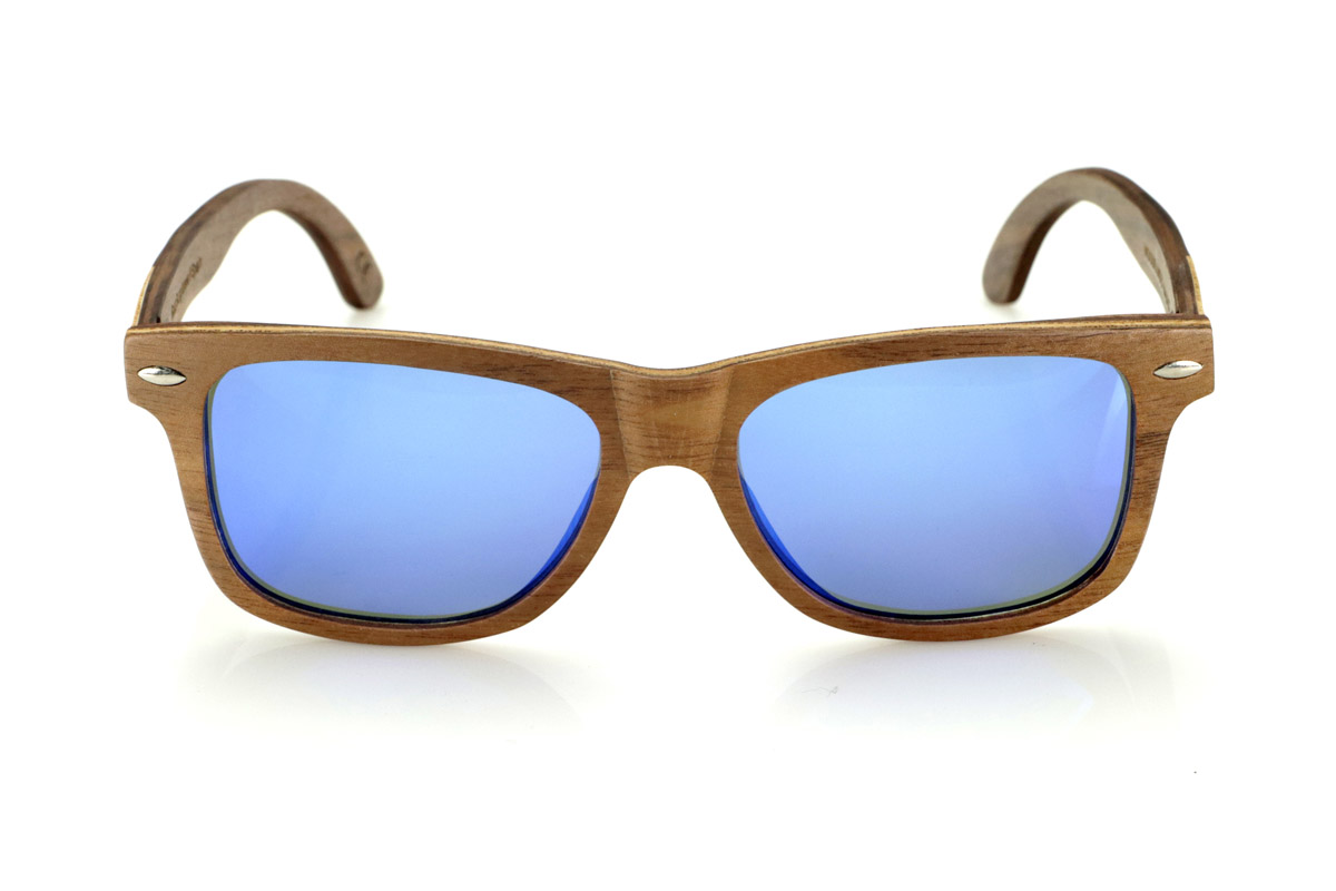 Gafas de Madera Natural de Walnut WOODSUNSET SK. Las gafas de sol de madera modelo Woodsunset están elaboradas en madera de nogal negro, ofreciendo un diseño elegante y atemporal con un acabado natural. Su estructura laminada incluye una lámina intercalada de arce natural, proporcionando un sutil contraste que realza su sofisticación.

Las patillas presentan un detalle único con una combinación de nogal y roble, aportando un toque distintivo a este modelo. Además, el frontal cuenta con pequeños adornos metálicos, que no solo refuerzan la estructura, sino que también aportan un aire vintage a su diseño.

Gracias a su forma clásica y versátil, las Woodsunset son una excelente opción tanto para hombres como para mujeres que buscan unas gafas de madera con carácter y estilo.

Medidas: 147x47 Calibre: 49 Venta al Por Mayor y Detalle | Root Sunglasses® 