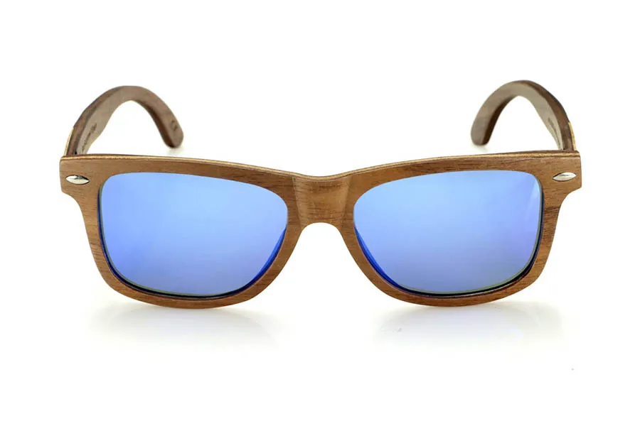 Gafas de Madera Natural de Walnut WOODSUNSET SK. Las gafas de sol de madera modelo Woodsunset están elaboradas en madera de nogal negro, ofreciendo un diseño elegante y atemporal con un acabado natural. Su estructura laminada incluye una lámina intercalada de arce natural, proporcionando un sutil contraste que realza su sofisticación.

Las patillas presentan un detalle único con una combinación de nogal y roble, aportando un toque distintivo a este modelo. Además, el frontal cuenta con pequeños adornos metálicos, que no solo refuerzan la estructura, sino que también aportan un aire vintage a su diseño.

Gracias a su forma clásica y versátil, las Woodsunset son una excelente opción tanto para hombres como para mujeres que buscan unas gafas de madera con carácter y estilo.

Medidas: 147x47 Calibre: 49 Venta al Por Mayor y Detalle | Root Sunglasses® 