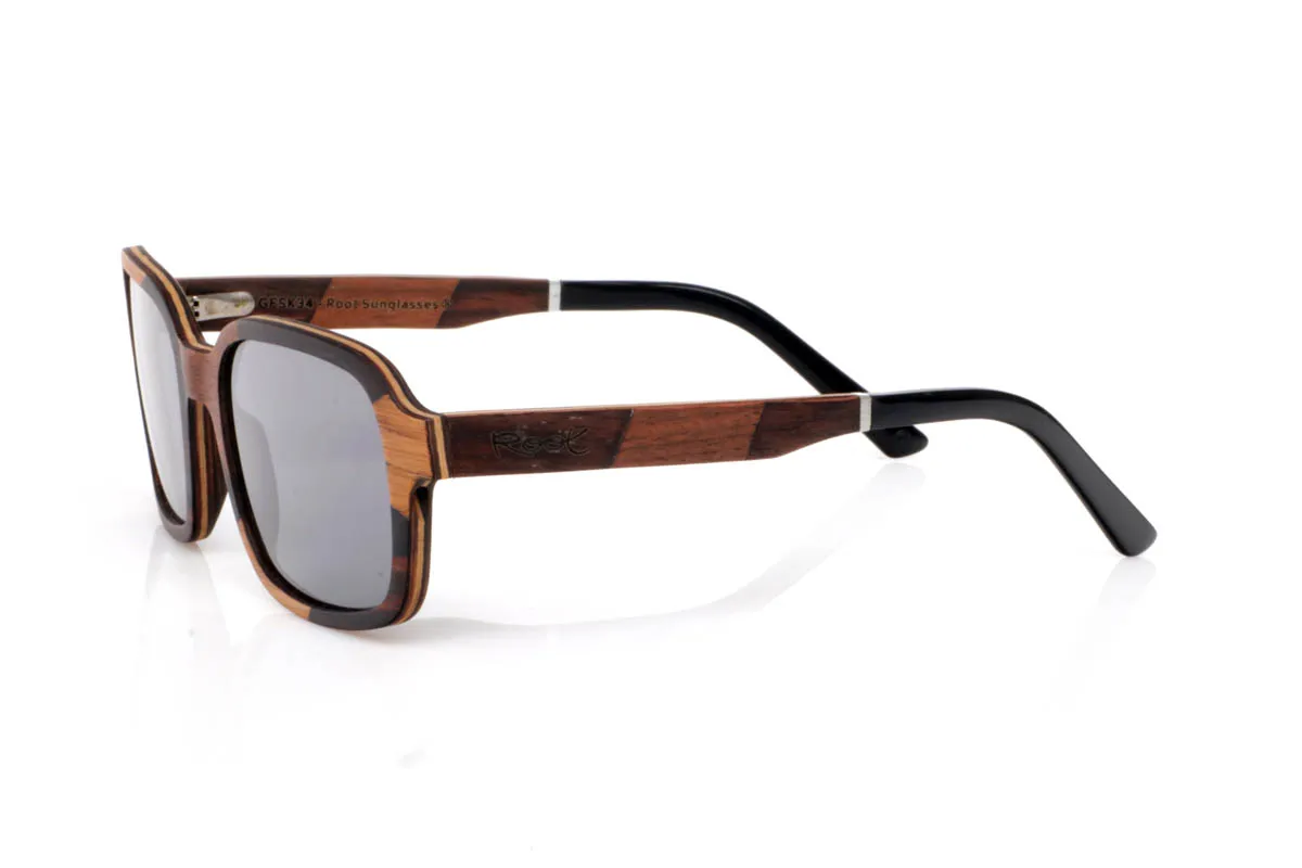 Gafas de Madera Natural de Ébano LENNY. Las gafas de madera LENNY tienen una presencia que se siente firme pero sin imponerse. El frontal combina la profundidad del ébano con la calidez del roble y nogal, creando un contraste marcado pero equilibrado. La forma, de líneas rectas suavizadas, aporta carácter y encaja con naturalidad en un estilo cotidiano con personalidad.

La mezcla de maderas en las varillas añade riqueza visual y textura, con vetas visibles que hacen que cada gafa sea diferente. Se sienten sólidas pero ligeras, cómodas desde el primer momento. De esas piezas que no necesitan exagerar para transmitir seguridad, calma y autenticidad.

Protección completa frente a los rayos UV.

Medidas: 142x48
Calibre: 52 Venta al Por Mayor y Detalle | Root Sunglasses® 