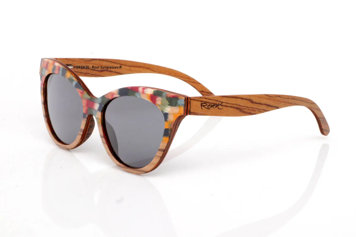 Gafas de Madera Natural de Zebrano GHANA. Las gafas de madera GHANA destacan por una energía diferente, más atrevida, más viva. El frontal mezcla la veta natural del zebrano con un patrón multicolor que rompe con lo esperado, creando una pieza única que no pasa desapercibida. La forma, ligeramente cat-eye y envolvente, aporta personalidad sin perder equilibrio.

Las varillas mantienen la esencia natural de la madera, con vetas marcadas que contrastan con el juego de colores del frontal. El resultado es ligero, cómodo y muy expresivo. Un modelo para quienes no buscan encajar, sino mostrar su forma de ver el mundo con autenticidad.

Protección completa frente a los rayos UV.

Medidas: 148x53
Calibre: 54 Venta al Por Mayor y Detalle | Root Sunglasses® 
