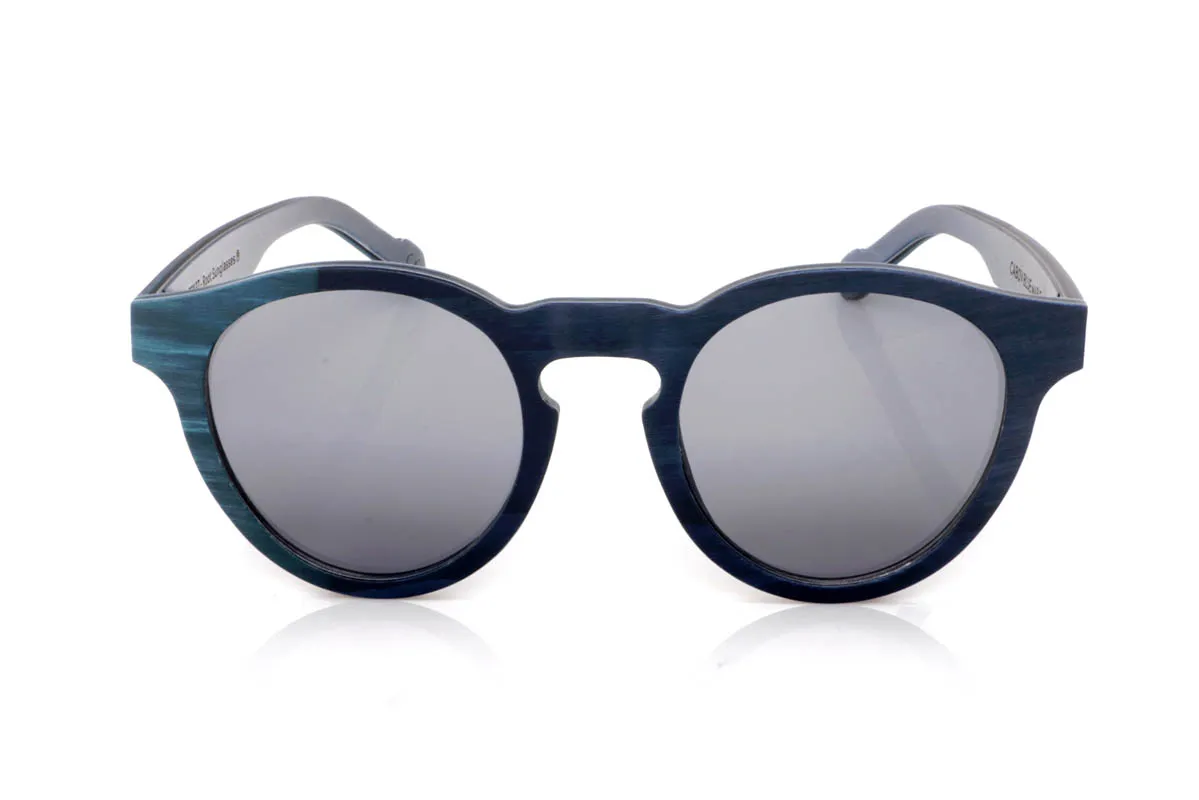 Gafas de Madera Natural de Arce CABOY. Las gafas de madera CABOY transmiten calma desde el primer momento. El frontal en arce tintado en dos tonos de azul crea un degradado sutil que recuerda al mar en calma, con matices que cambian según la luz. La forma redondeada aporta suavidad y equilibrio, haciendo que el conjunto se sienta natural y fácil de llevar.

Las varillas continúan esa misma armonía, con la veta de la madera visible bajo el tinte, aportando profundidad y autenticidad. Son ligeras, cómodas y con una presencia tranquila pero con carácter. Un modelo que no necesita destacar para hacerse notar.

Protección completa frente a los rayos UV.

Medidas: 147x50
Calibre: 49 Venta al Por Mayor y Detalle | Root Sunglasses® 