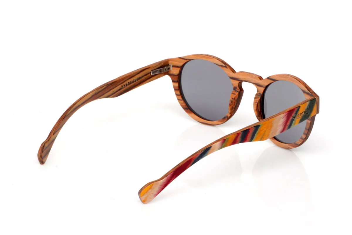 Gafas de Madera Natural de Arce KRETA SK. Las gafas de madera KRETA tienen algo especial desde el primer vistazo. El frontal combina la base natural del arce con un acabado multicolor lleno de matices, como pinceladas sobre madera que aportan energía y personalidad. La forma redondeada suaviza el conjunto y equilibra ese carácter más expresivo, creando una pieza original pero fácil de llevar.

Las varillas mantienen la esencia natural del arce, dejando ver su veta única, mientras el toque de color en el frontal aporta un contraste vibrante. Son ligeras, cómodas y diferentes, pensadas para quienes buscan algo más que unas gafas: una forma de expresar su estilo con naturalidad.

Protección completa frente a los rayos UV.

Medidas: 143x51
Calibre: 49 Venta al Por Mayor y Detalle | Root Sunglasses® 