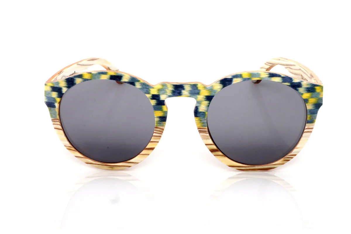 Gafas de Madera Natural de Zebrano TORLA. Las gafas de madera TORLA ICE TREE transmiten una energía diferente desde el primer momento. El frontal combina la veta clara natural con un patrón geométrico en tonos verdes, amarillos y azulados que recuerda a la luz filtrándose entre hojas. Una mezcla viva pero equilibrada, que aporta carácter sin resultar excesiva.

La forma redondeada suaviza el conjunto y las hace muy llevables en el día a día, mientras que las varillas mantienen la calidez de la madera natural, creando un contraste muy agradable. Son ligeras, cómodas y con personalidad propia, pensadas para quienes buscan algo distinto sin renunciar a la naturalidad.

Protección completa frente a los rayos UV.

Medidas: 147x49
Calibre: 52 Venta al Por Mayor y Detalle | Root Sunglasses® 