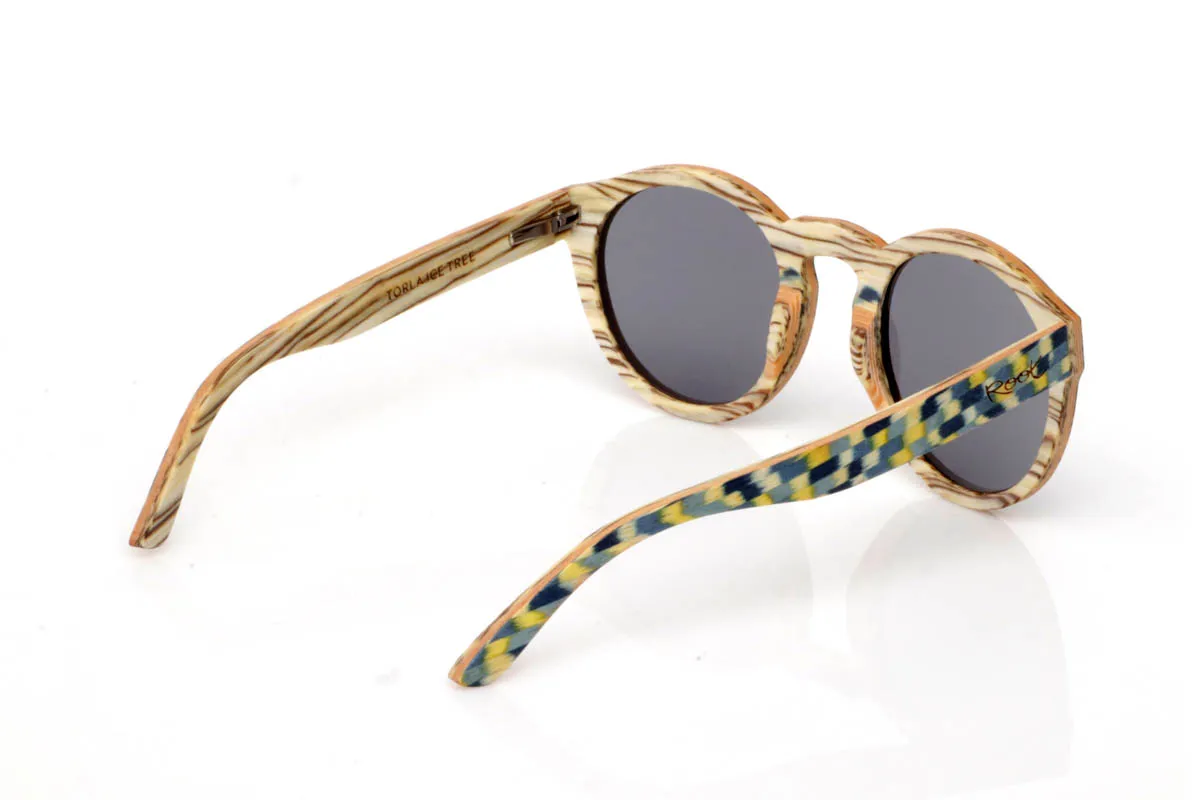 Gafas de Madera Natural de Zebrano TORLA. Las gafas de madera TORLA ICE TREE transmiten una energía diferente desde el primer momento. El frontal combina la veta clara natural con un patrón geométrico en tonos verdes, amarillos y azulados que recuerda a la luz filtrándose entre hojas. Una mezcla viva pero equilibrada, que aporta carácter sin resultar excesiva.

La forma redondeada suaviza el conjunto y las hace muy llevables en el día a día, mientras que las varillas mantienen la calidez de la madera natural, creando un contraste muy agradable. Son ligeras, cómodas y con personalidad propia, pensadas para quienes buscan algo distinto sin renunciar a la naturalidad.

Protección completa frente a los rayos UV.

Medidas: 147x49
Calibre: 52 Venta al Por Mayor y Detalle | Root Sunglasses® 