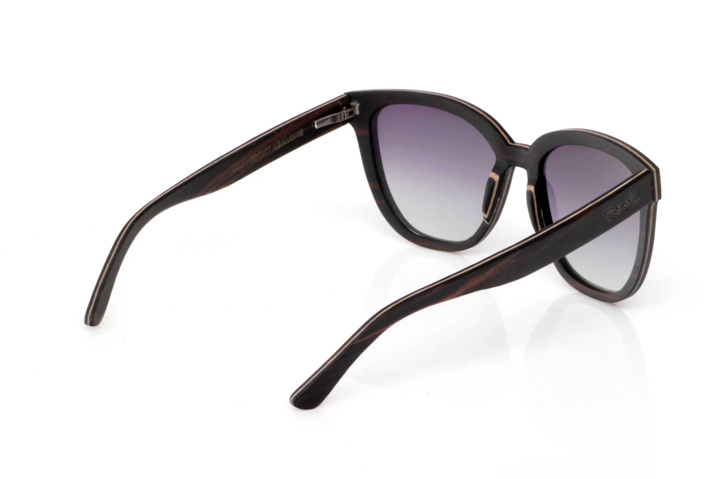 Wood eyewear of Ebony PALM. PALM wooden sunglasses stand out for their soft front shape with a subtle cat-eye touch that enhances the face without being too bold. The combination of dark ebony on the upper part and lighter wood on the lower section creates an elegant and well-balanced contrast.

The shape is flattering and easy to wear, with a relaxed and slightly feminine feel that fits effortlessly into everyday life. The temples continue the ebony look, with natural grain patterns that add depth and make each piece unique.

A design that conveys calm, balance, and effortless style.

Full UV protection.

Size: 145x47
Lens width: 54 for Wholesale & Retail | Root Sunglasses® 