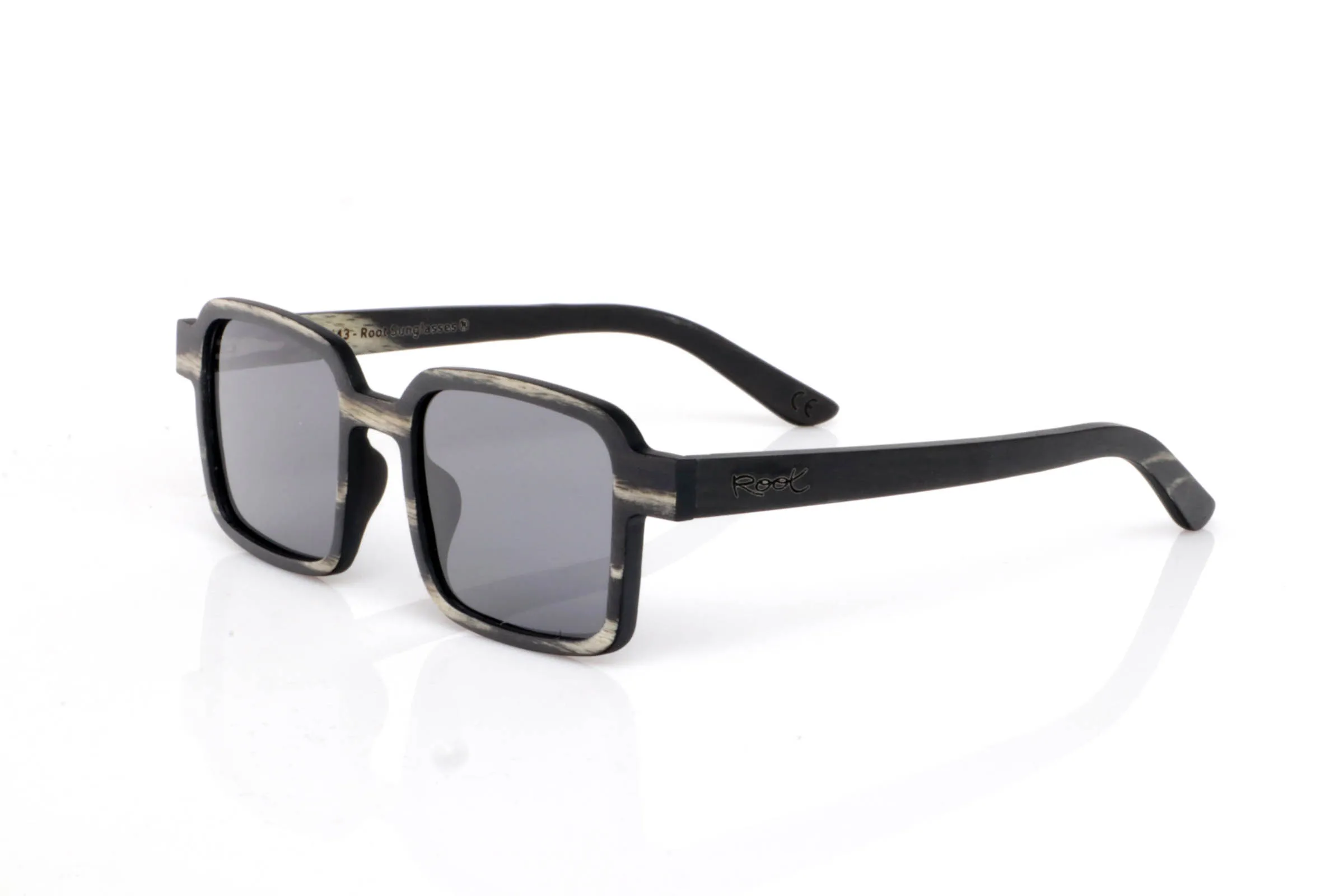 Gafas de Madera Natural de mpingo modelo MANU. Las gafas de madera MANU destacan por su frontal rectangular de líneas marcadas y proporciones compactas, con un aire sólido y muy actual. El acabado en madera mpingo aporta un contraste único entre tonos oscuros y vetas claras que recorren la montura de forma orgánica.

El diseño transmite carácter sin necesidad de excesos. Es una gafa directa, equilibrada y muy cómoda, pensada para quienes buscan algo diferente pero fácil de llevar en el día a día.

Las varillas mantienen la continuidad del tono oscuro, reforzando esa sensación de pieza compacta y bien definida, donde cada detalle suma.

Protección completa frente a los rayos UV.

Medidas: 135x45
Calibre: 45 | Root Sunglasses® 